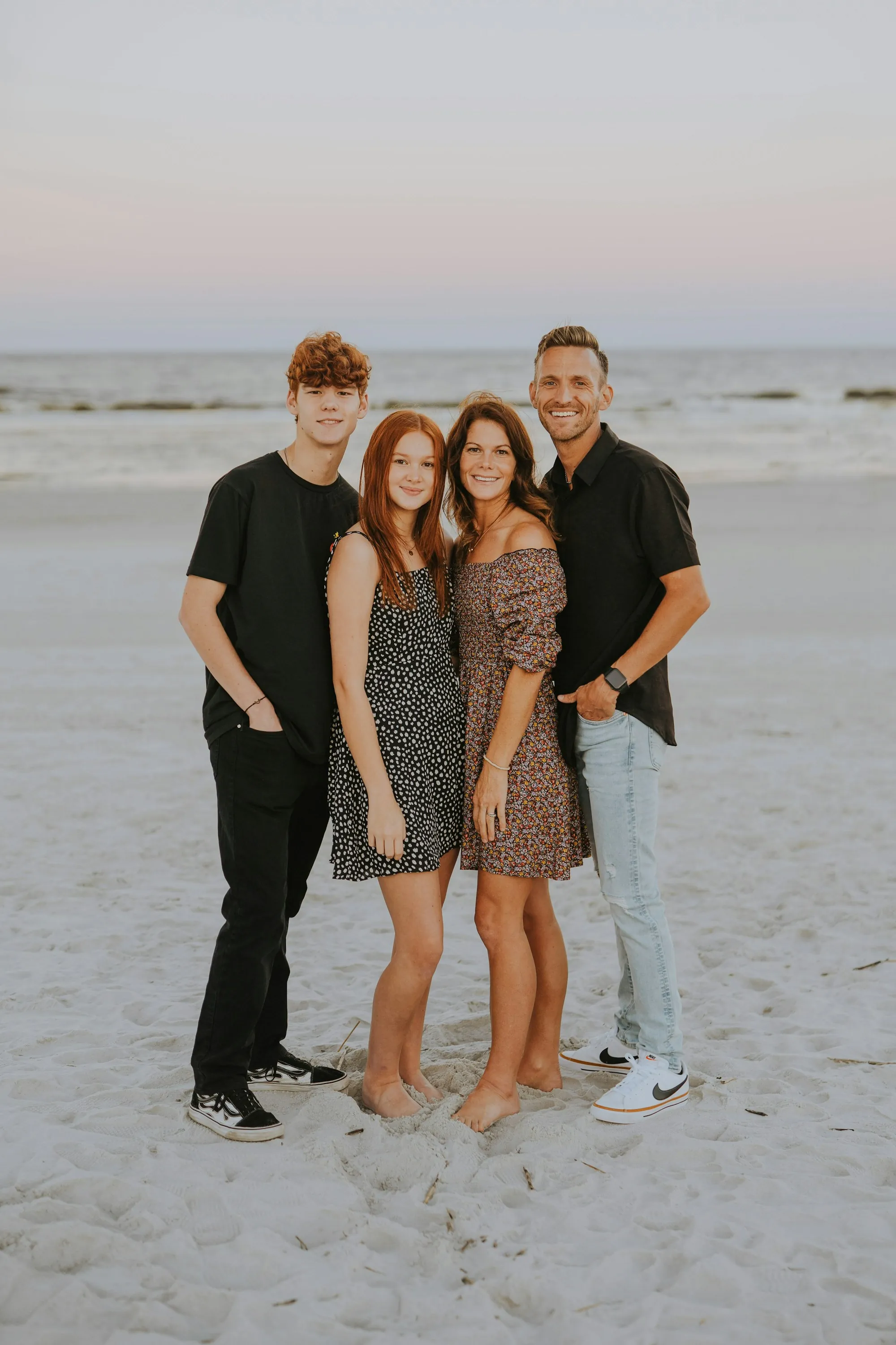 Parents and two teenage children standing on a beach